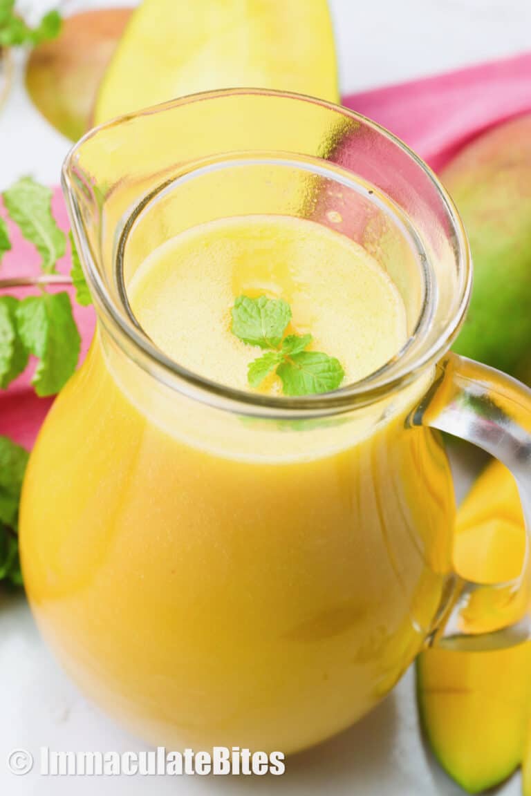 A pitcher of mango muice garnished with mint