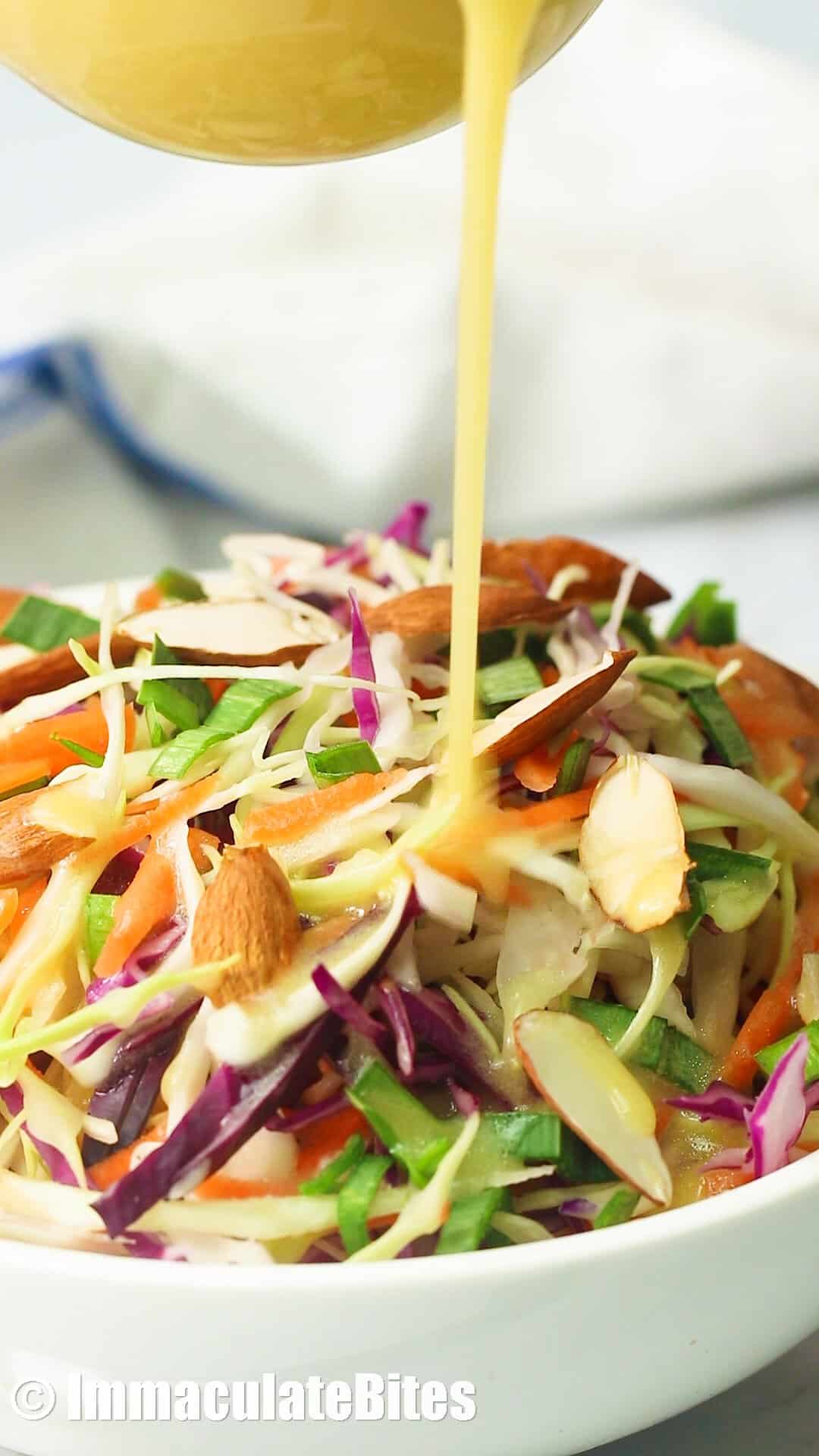 Closeup of vinegar coleslaw being drizzled with dressing