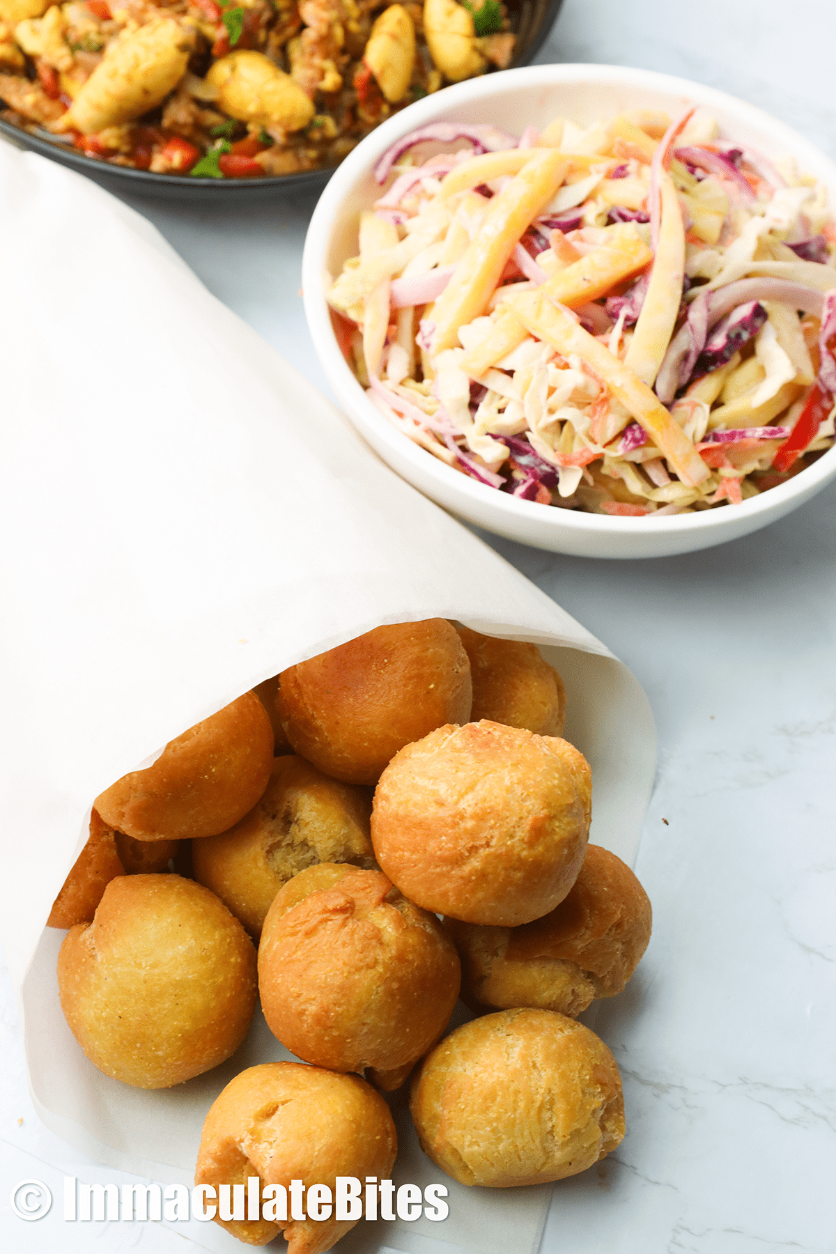 Jamaican fried dumplings are wrapped and served with mango coleslaw