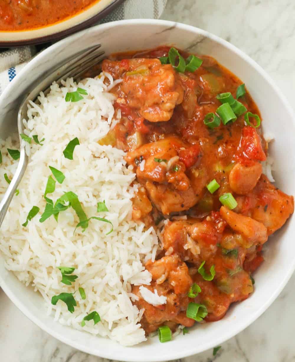 A bowl of chicken etouffee with white rice