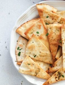 A white plate with fresh pita chips