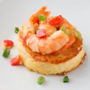 A grit cake with sauce and shrimp