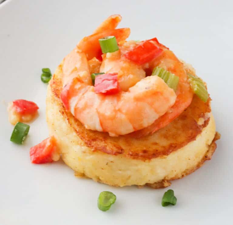 A grit cake with sauce and shrimp