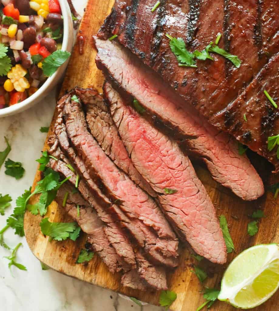 Grilled flank steak sliced perfectly with black bean and corn salad