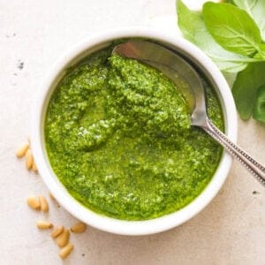 Pesto in a white bowl with a spoon