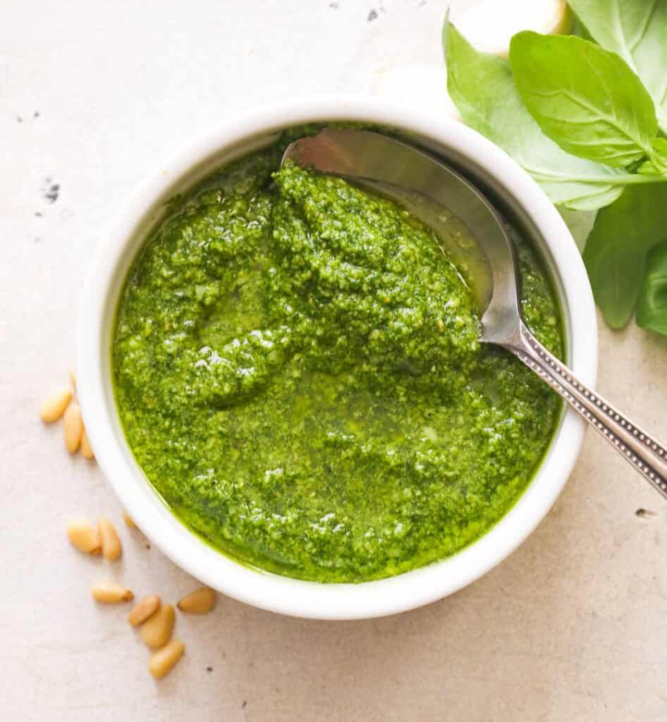 Pesto in a white bowl with a spoon