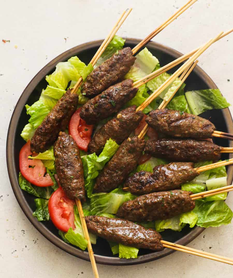 Kofta Kabob on a skewer over lettuce and tomatoes