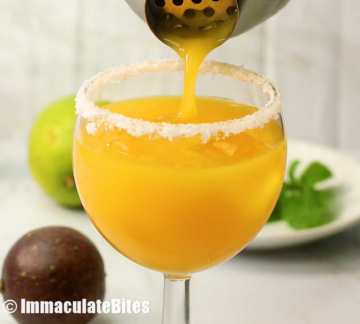 Pouring a glass of passion fruit margarita