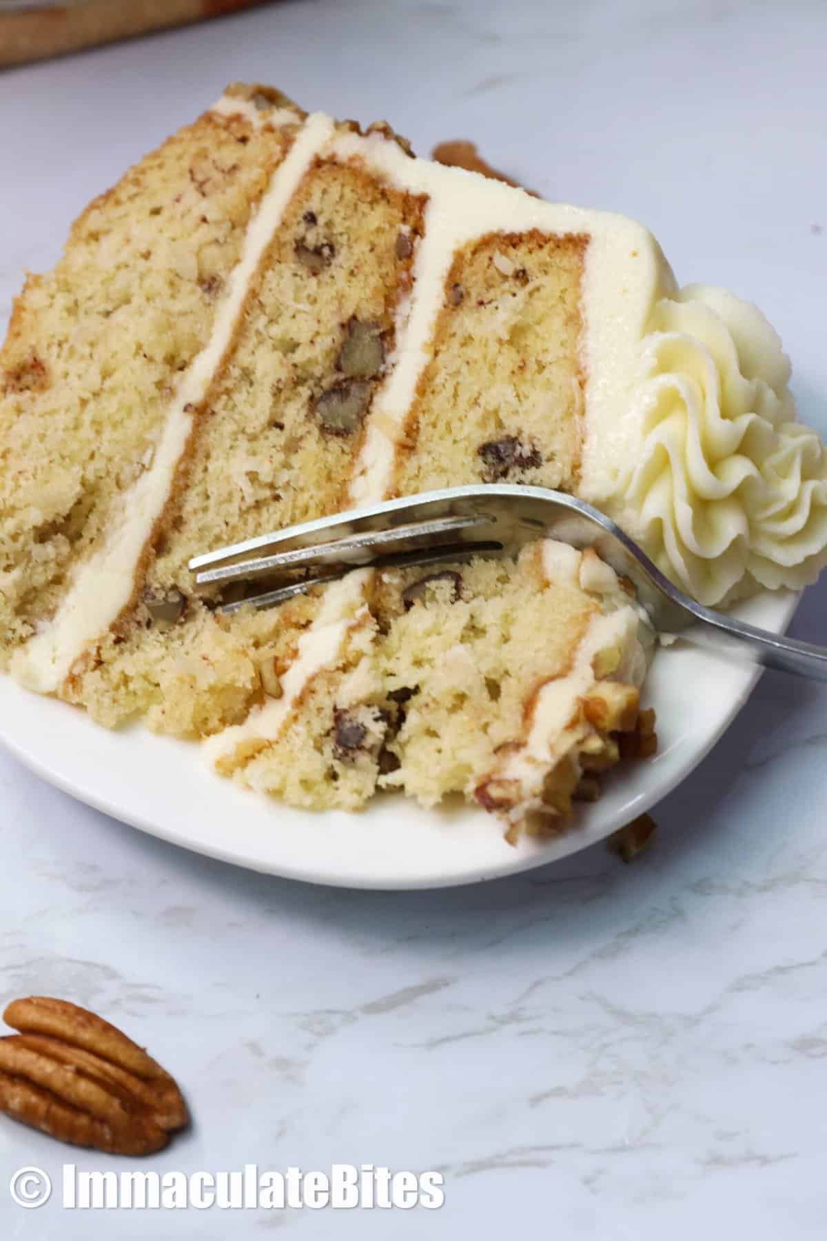 A slice of Italian Cream cake with a fork