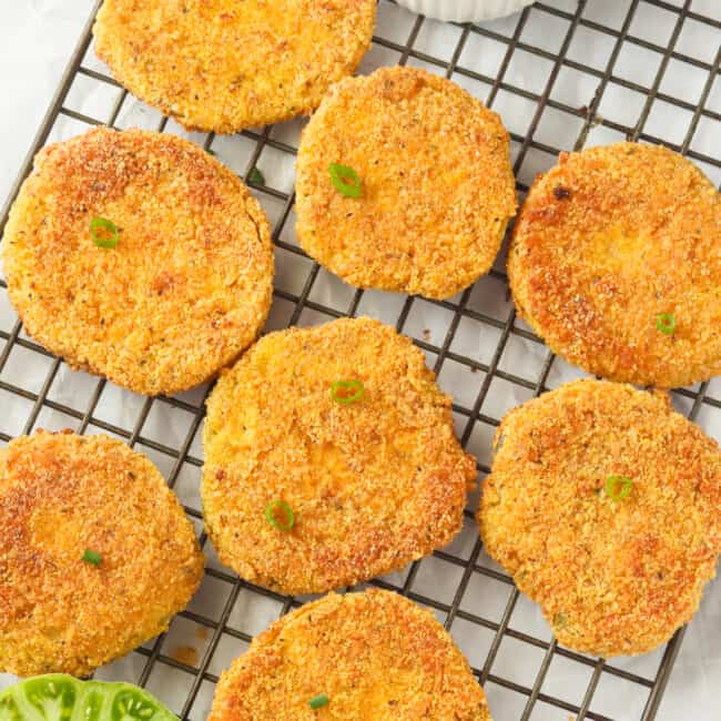 Freshly fried green tomatoes cooling on a rack