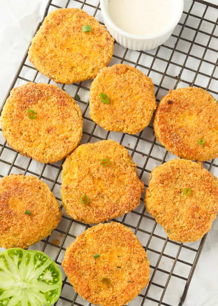 Freshly fried green tomatoes cooling on a rack