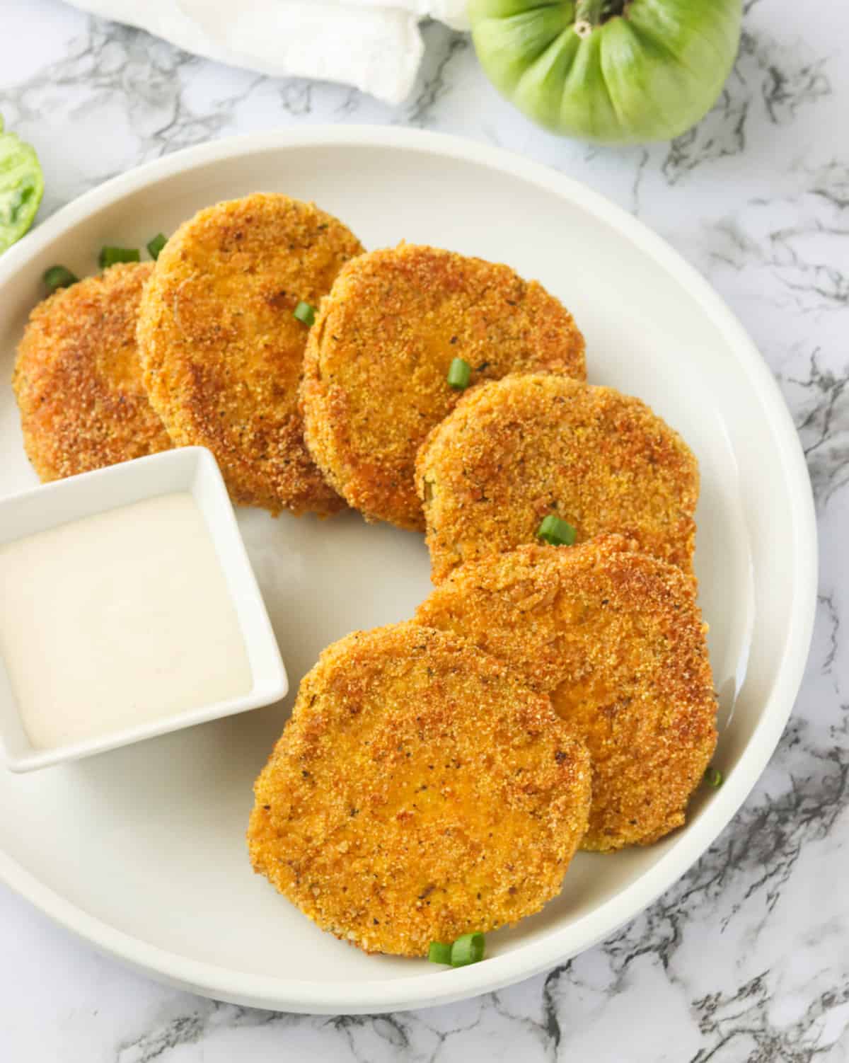 Fried green tomatoes with remoulade on a white plate