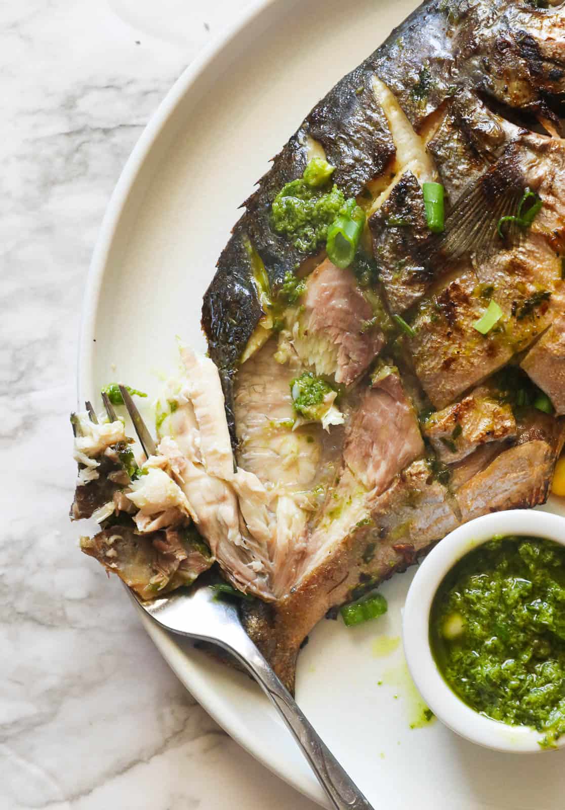 Grilled pompano fish with sliced ​​lemon and parsley