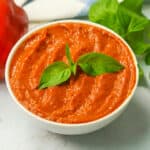 Roasted red pepper sauce garnished with fresh basil leaves