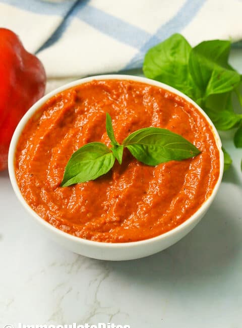 Roasted red pepper sauce garnished with fresh basil leaves