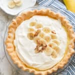 A whole banana cream pie topped with sliced bananas