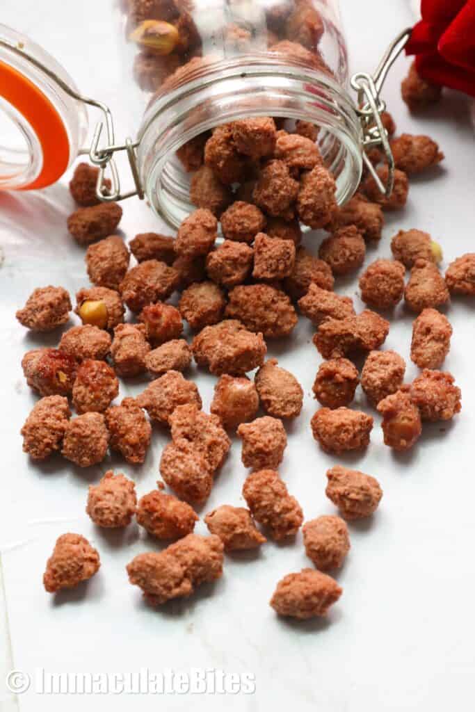 A glass jar with candied nuts spilling out