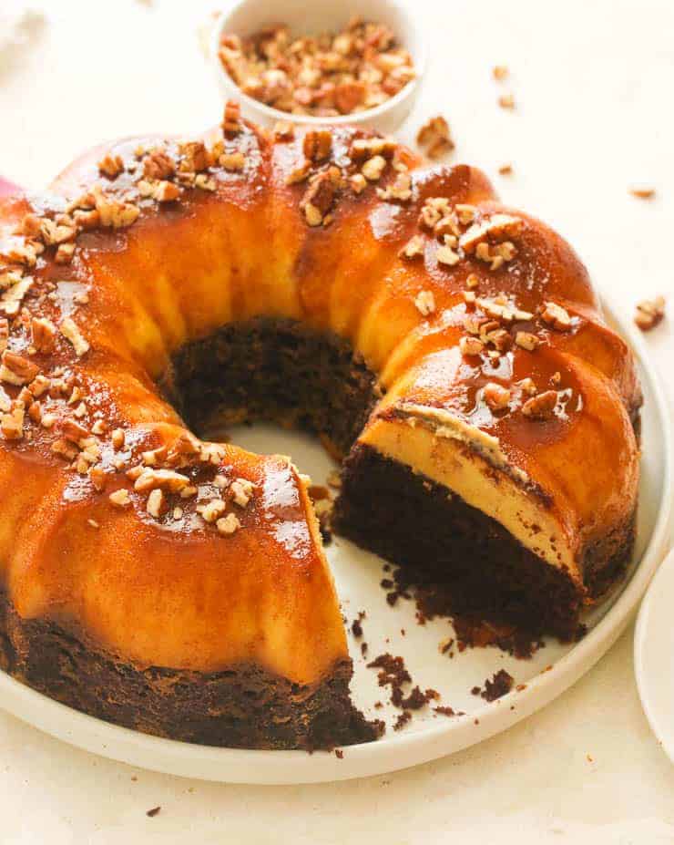 Chocoflan topped with nuts and a slice removed