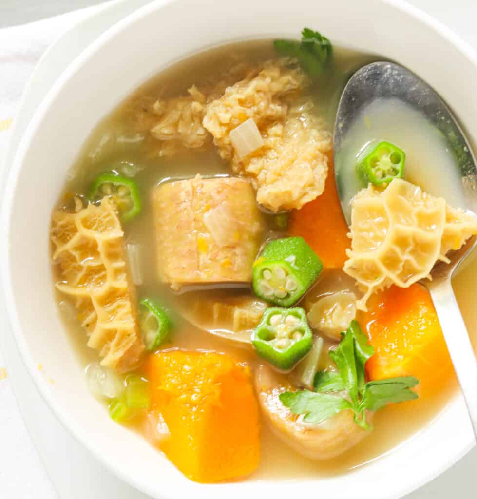 A bowl of beef tripe soup with a spoon