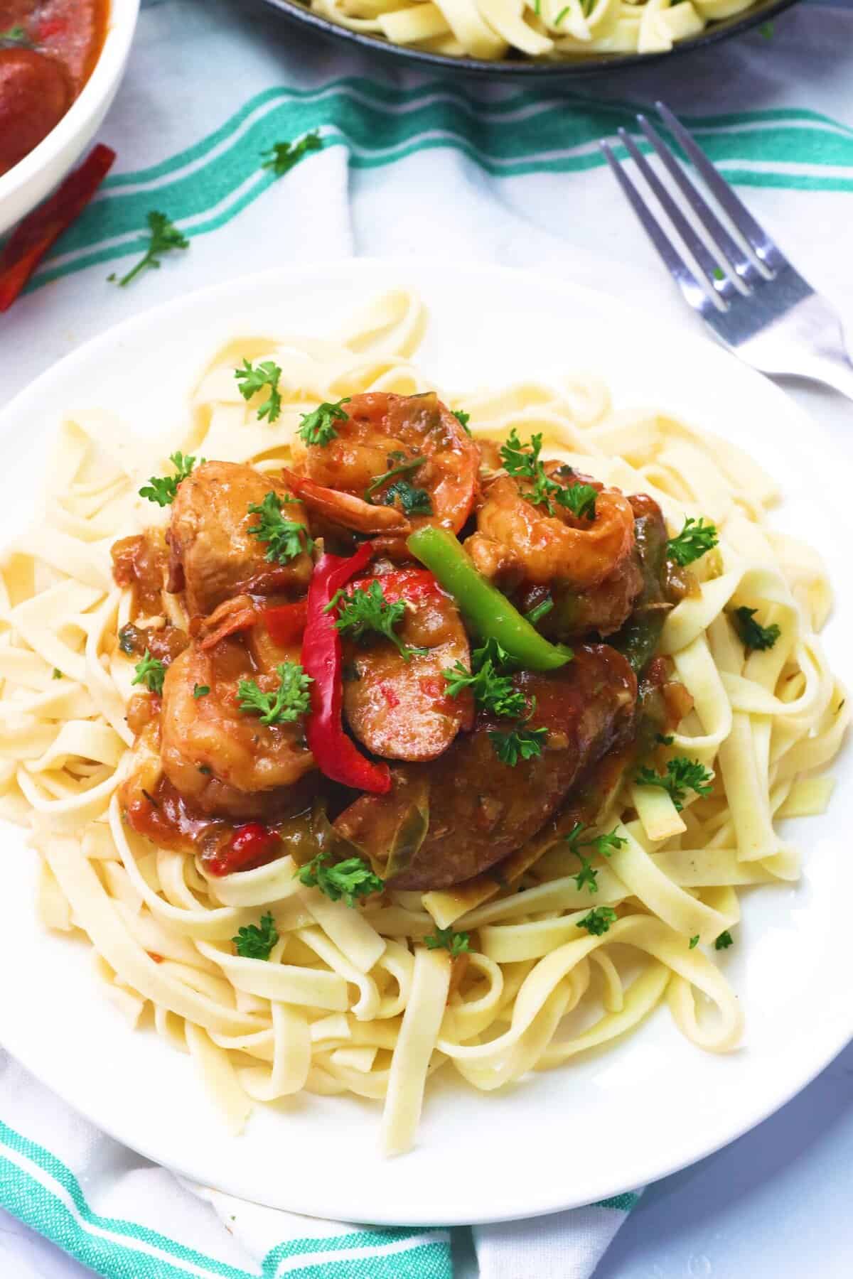Enjoying pasta smothered in mouthwatering Cajun jambalaya for a delicious dinner.