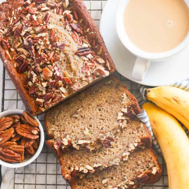 Freshly baked banana nut bread sliced and ready to serve with a cup of coffee