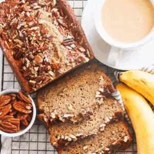 Freshly baked banana nut bread sliced and ready to serve with a cup of coffee