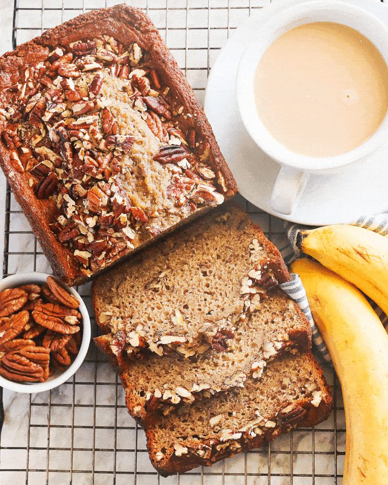 Freshly baked banana nut bread sliced and ready to serve with a cup of coffee