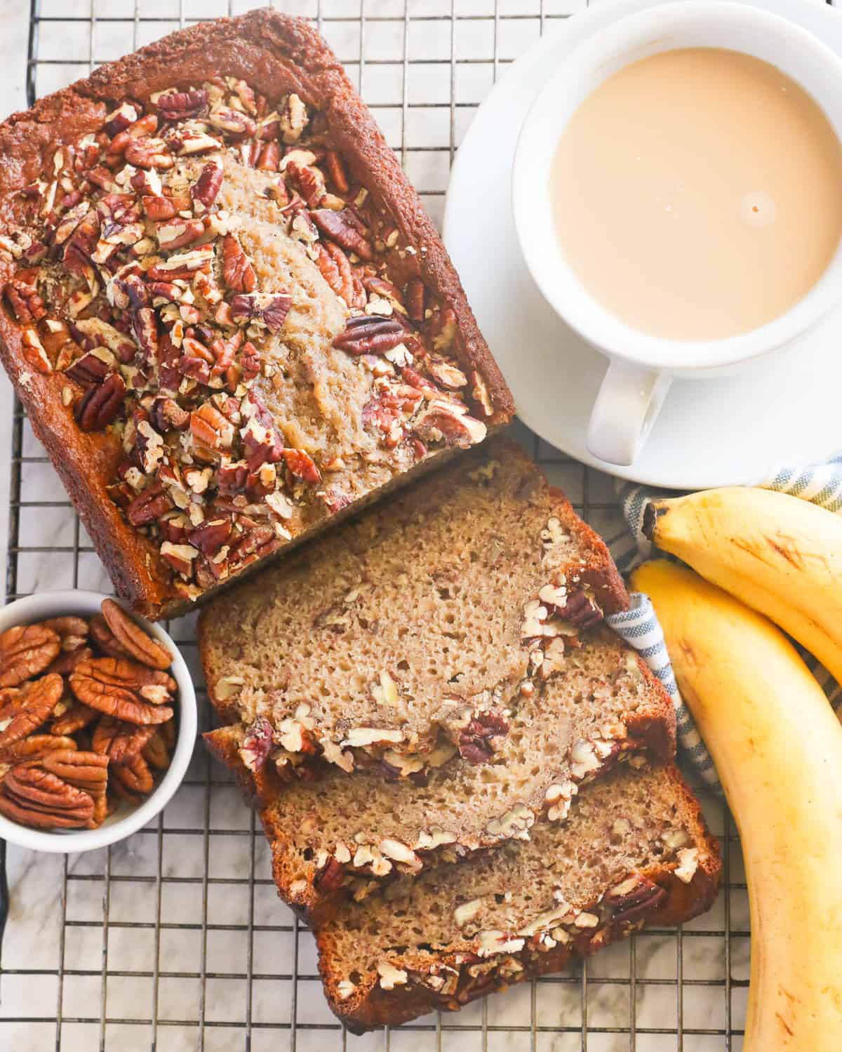 Freshly baked banana nut bread sliced and ready to serve with a cup of coffee