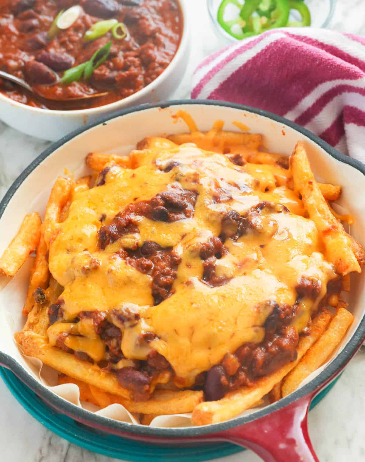 A skillet full of crazy delicious chili cheese fries