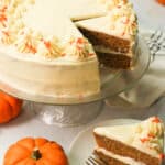 Pumpkin Cake with a slice served and cute mini pumpkins in the foreground