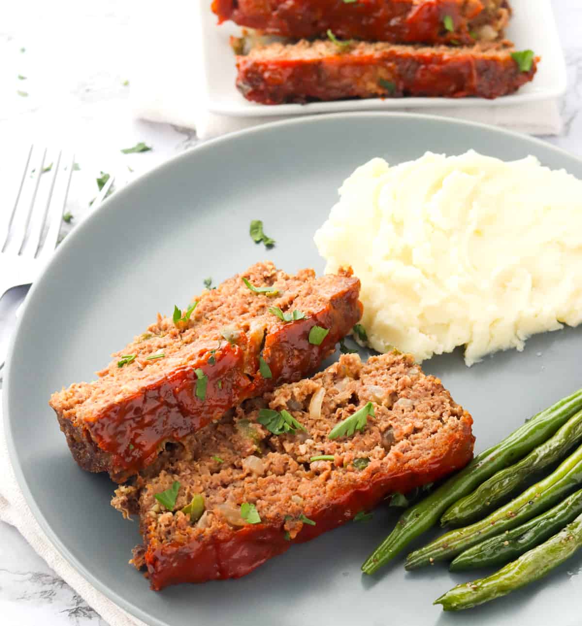 Enjoying meatloaf with roasted green beans and mashed potatoes