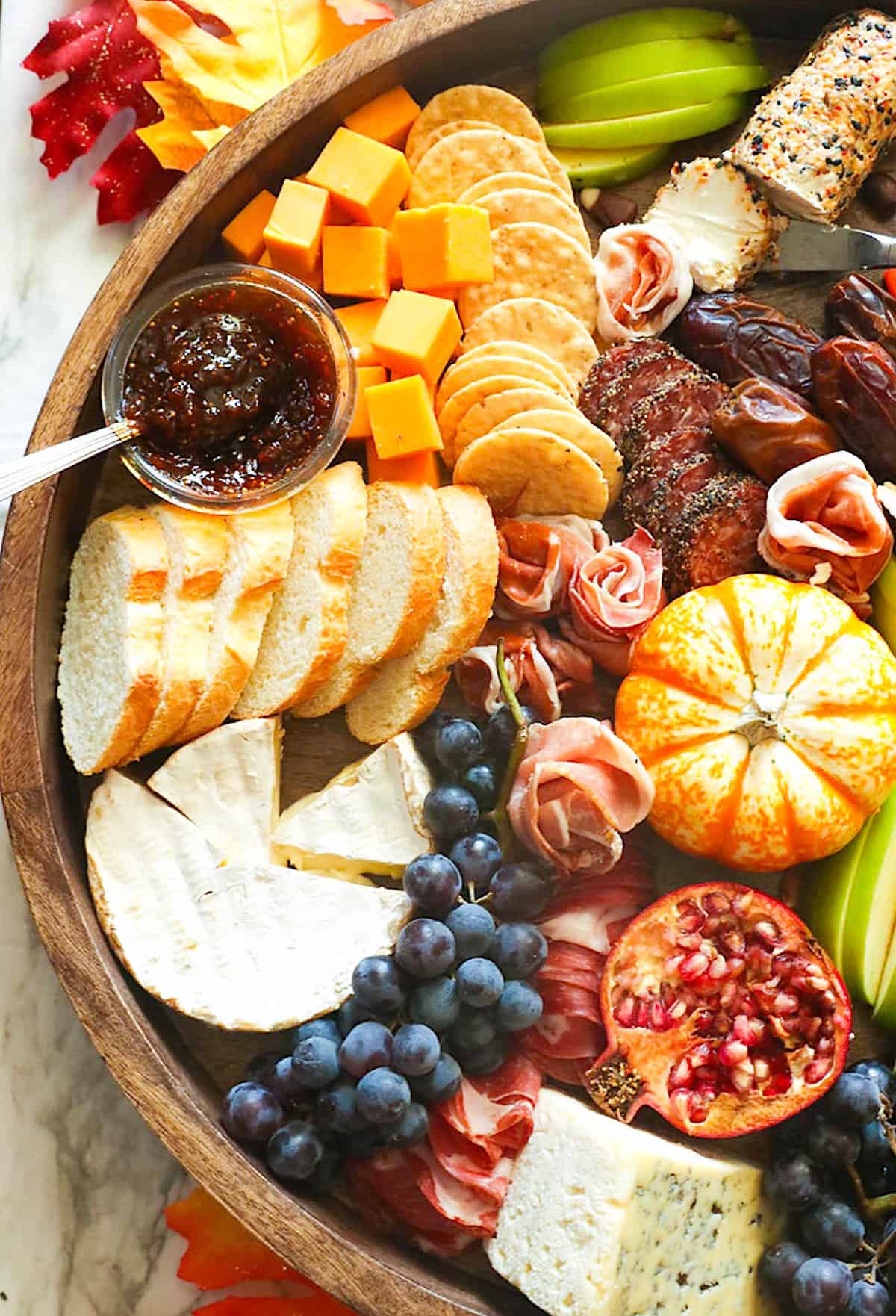 A beautifully scrumptious Thanksgiving charcuterie board with fruit, cheese, meat, and crackers