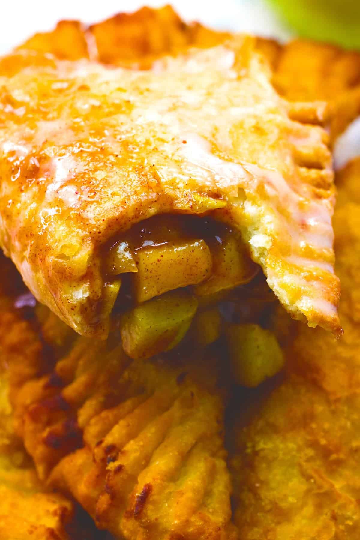 Breaking open a handheld apple pie to reveal the delicious, chunky filling.