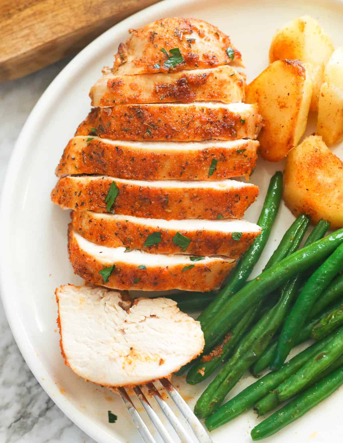 Enjoy grilled chicken breast with green beans and roast potatoes
