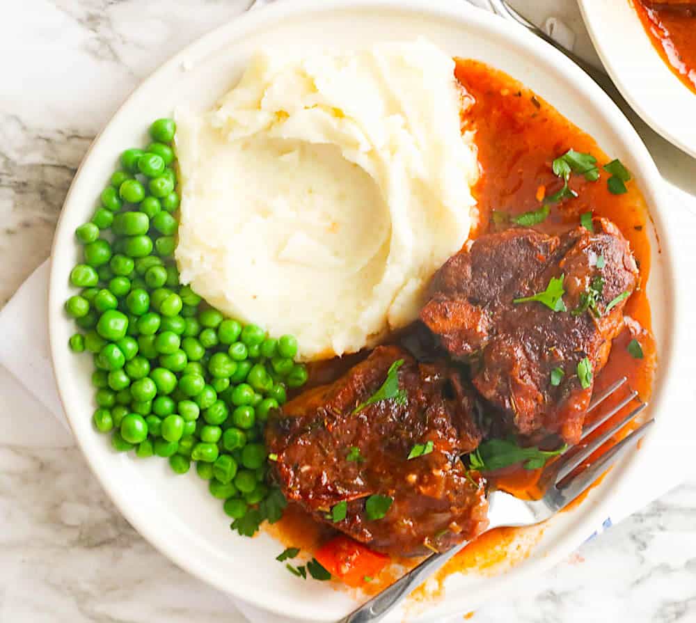 Côtelettes de longe d'agneau incroyablement délicieuses avec purée de pommes de terre et petits pois