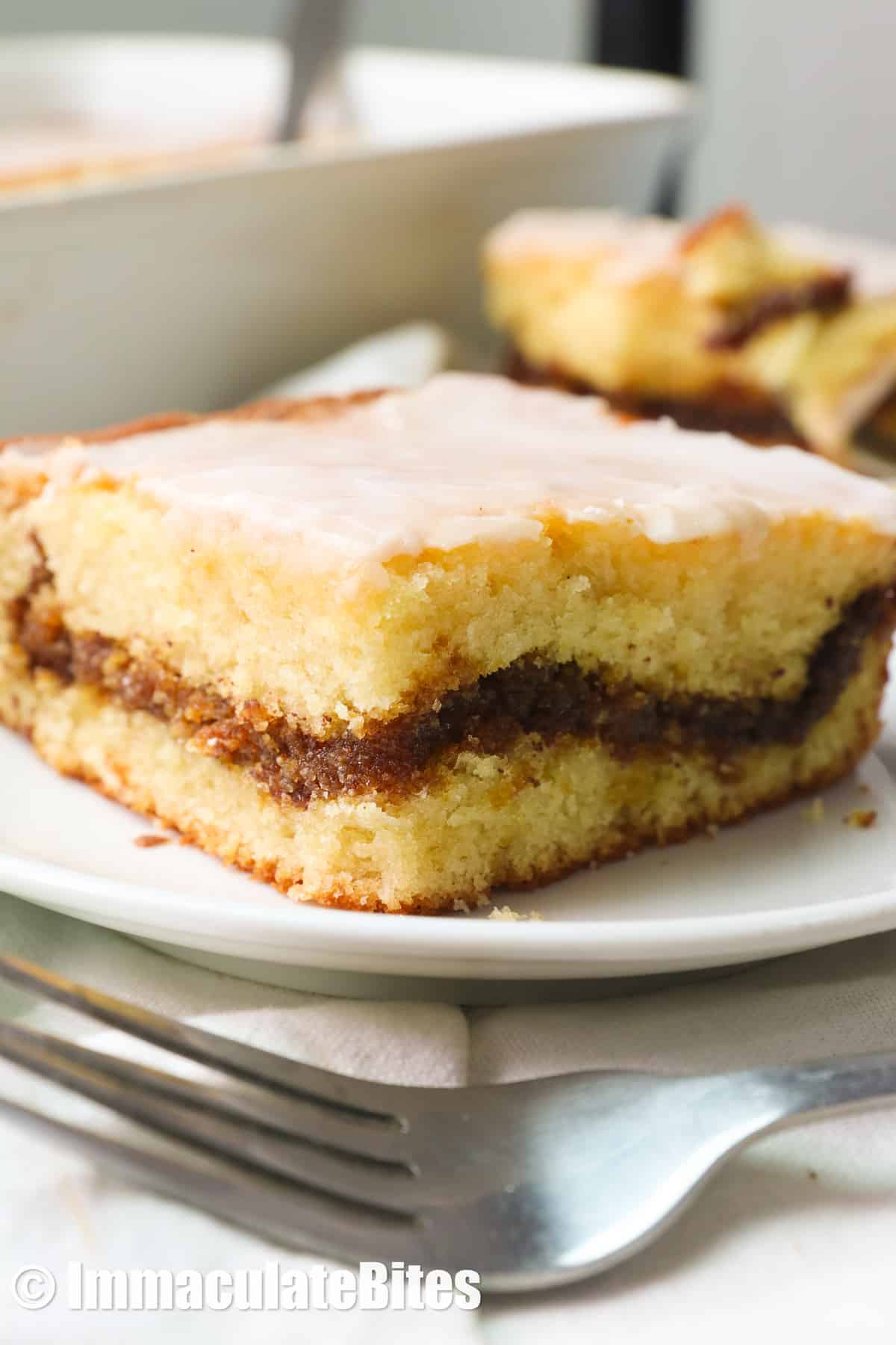Honey Bun Cake with warm cinnamon swirls and drizzles of decadent vanilla glaze