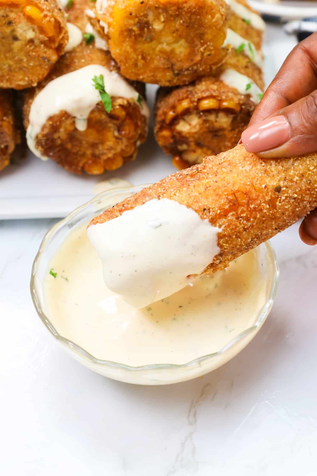 Enjoy Cajun Fried Corn on the Cob with ranch dressing or remoulade
