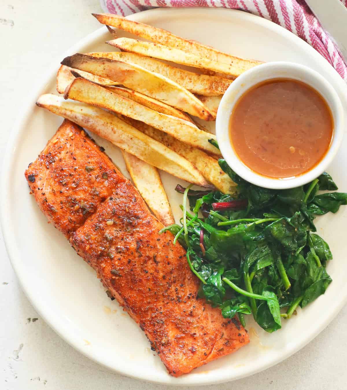 Jerk salmon with crispy jerk fries and wilted spinach