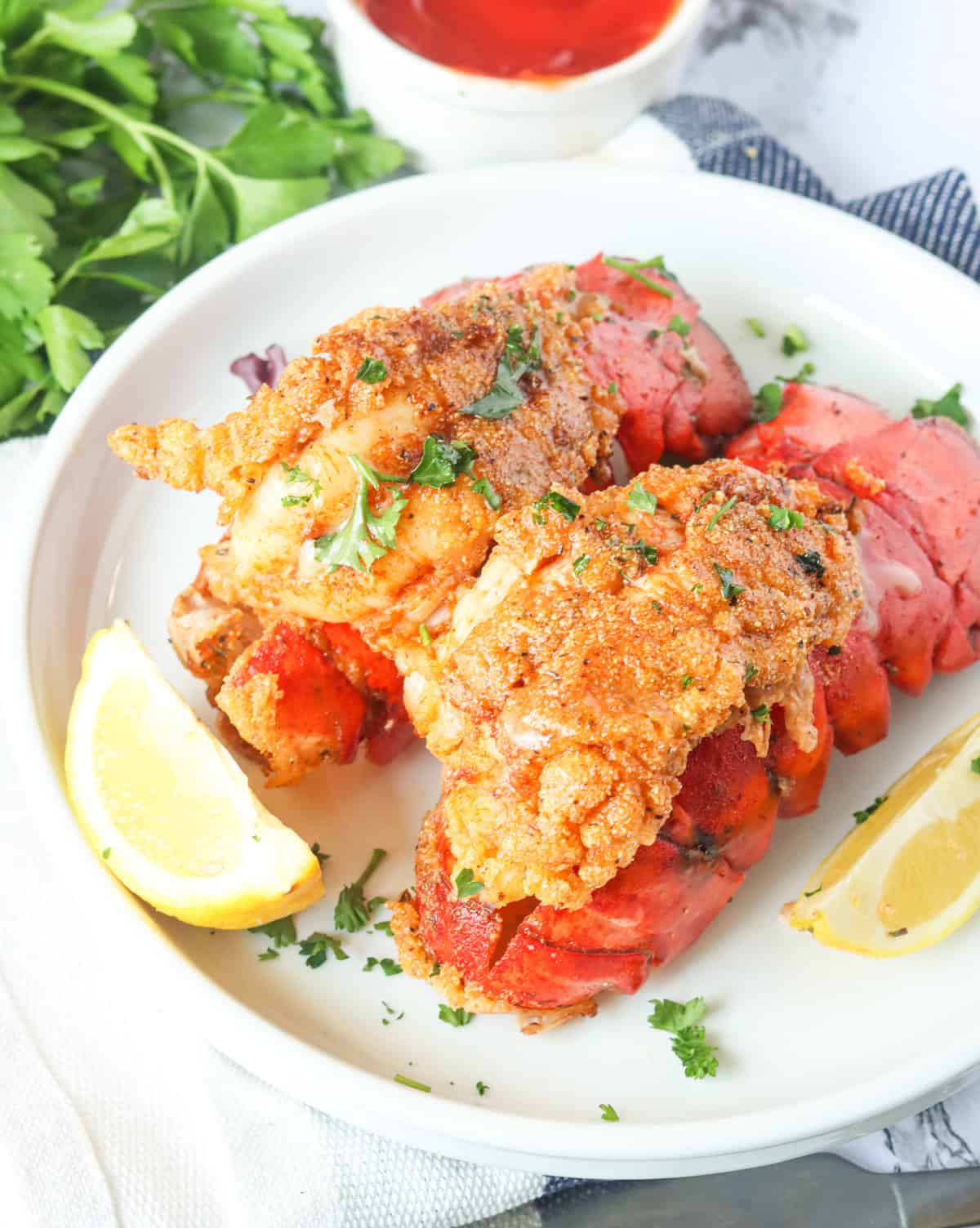 Enjoy decadent fried lobster tails with lemon wedges