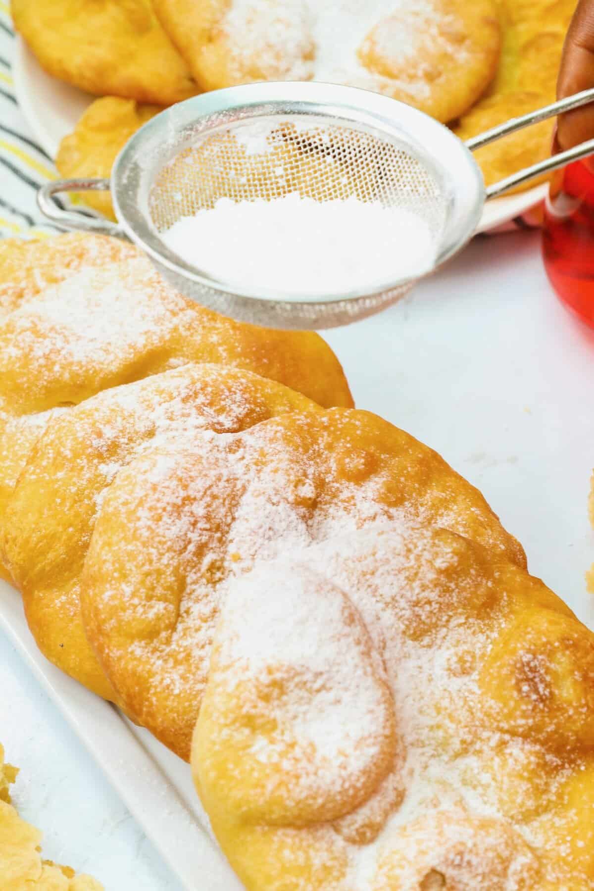 Sprinkle powdered sugar on exquisite fried dough