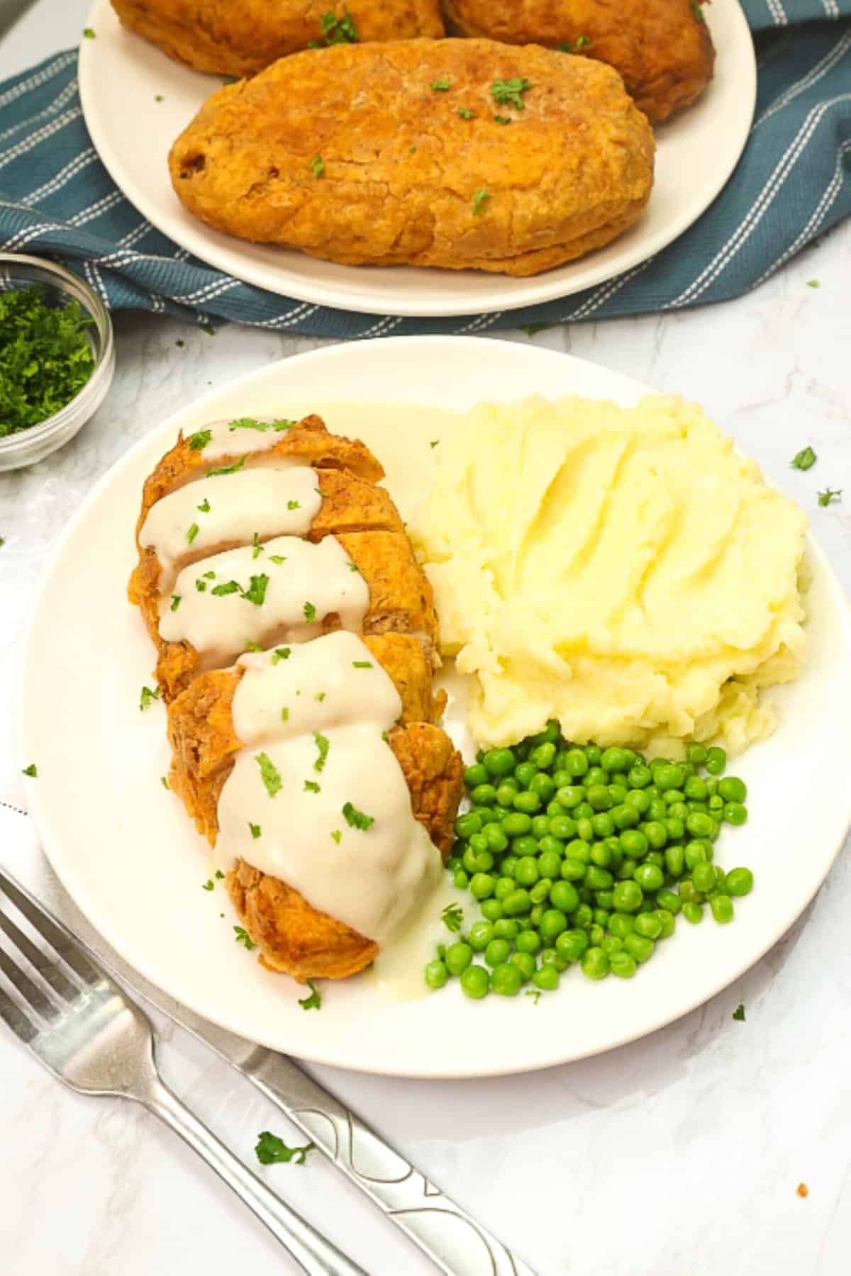 Enjoying pure comfort food with fried chicken breasts, mashed potatoes and satisfying peas
