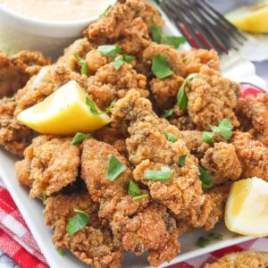 Enjoying a stack of delectable fried oysters with lemon wedges and sauce