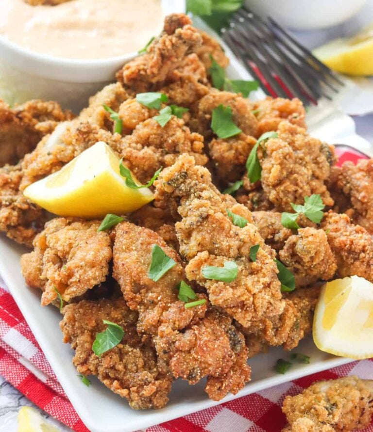 Enjoying a stack of delectable fried oysters with lemon wedges and sauce