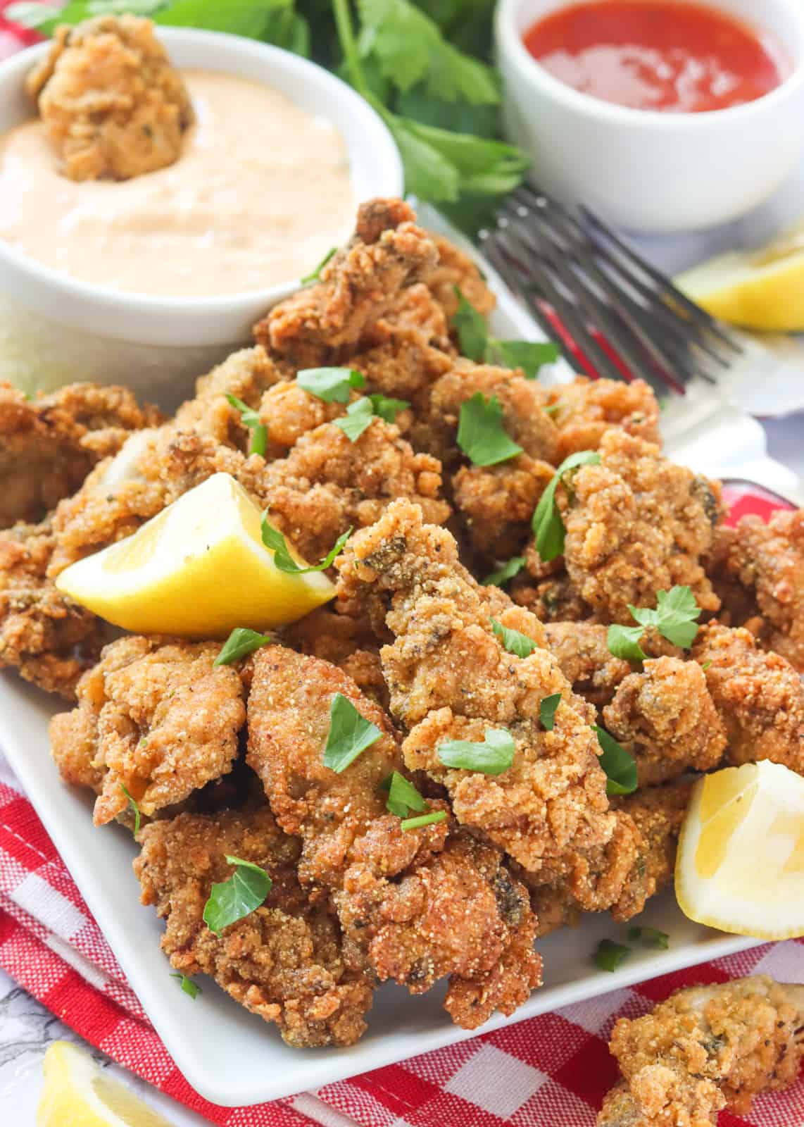 Enjoying a stack of delectable fried oysters with lemon wedges and sauce