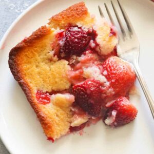 A decadent slice of strawberry cobbler freshly served on a white plate