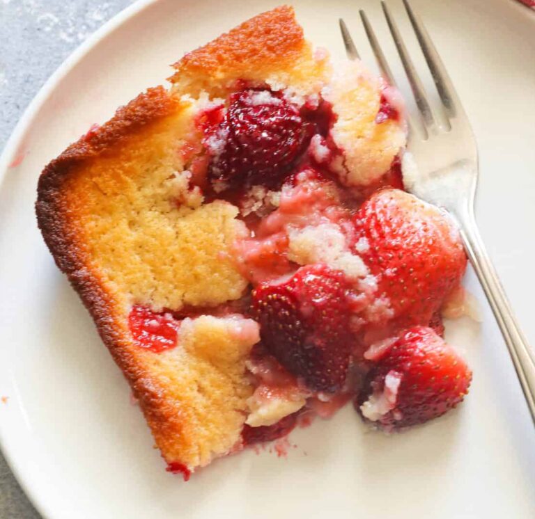 A decadent slice of strawberry cobbler freshly served on a white plate