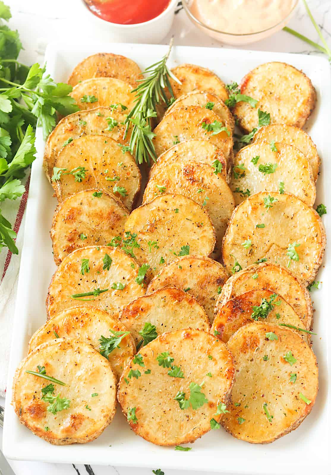 Baked sliced potatoes ready to enjoy on a white platter