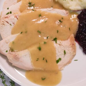 Drizzling easy turkey gravy without drippings over freshly roasted turkey breast with mashed potatoes