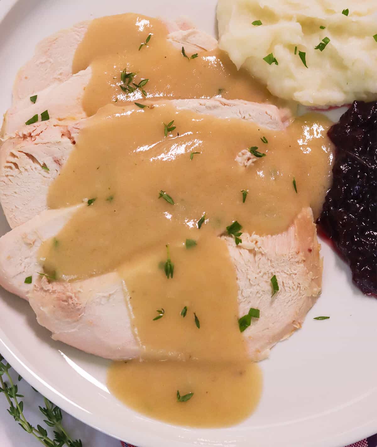 Drizzling easy turkey gravy without drippings over freshly roasted turkey breast with mashed potatoes