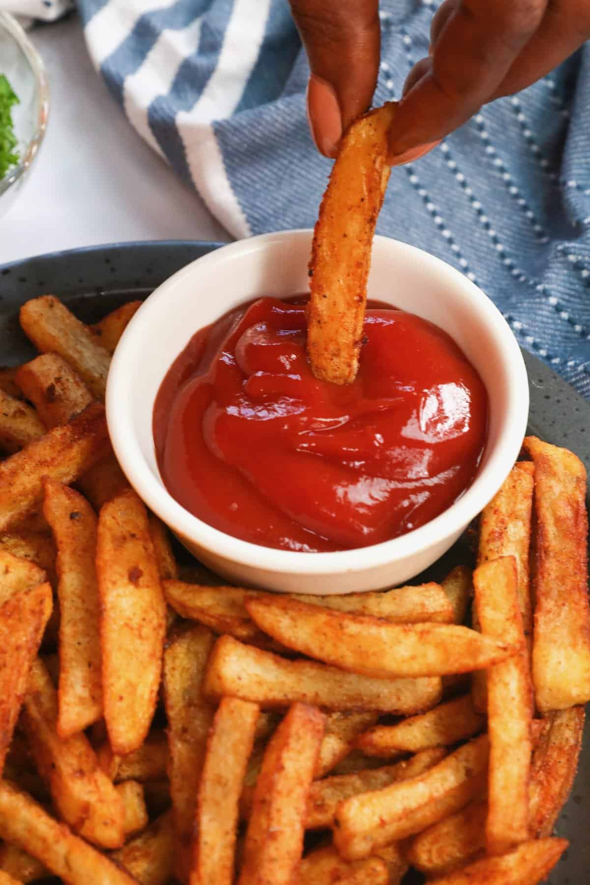 Dipping a crispy Cajun fry in ketchup for a great snack